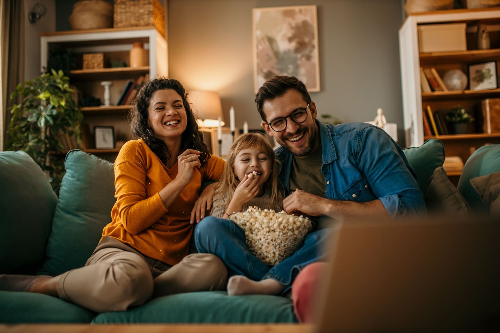 A family enjoying a film while saving on their subscription with a sharing platform Friendly Share.